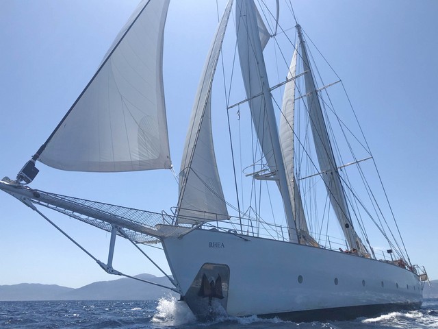 Der mächtige Schiffsbug der im Stil einer klassischen Yacht gebauten RHEA bricht sich seinen Weg durch die blaue See
