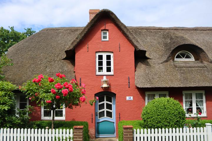 Friesenhäuser auf Amrum sind traditionell aus rotem Backstein gebaut und mit einem Reetdach gedeckt, das Wind und Wetter standhält