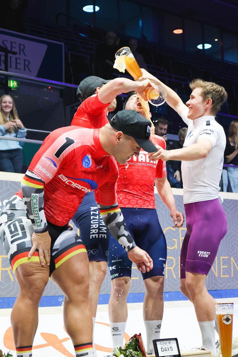 Obligatorische Bierdusche nach der Siegerehrung der 59. Sixdays: Michele Scartezzini und Simone Consonni (beide mitte) feiern den Sieg.