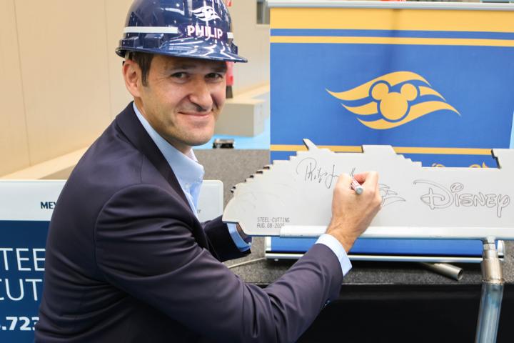 Beim Stahlschneiden der Baunummer S.723 auf der Meyer Werft in Papenburg setzt Philip Gennotte, Portfolio Senior Excutive Project Manager Neubauten bei Walt Disney Imagineering Deutschland, symbolisch seine Unterschrift auf die frisch gelaserte Silhouette vom Neubau – ein feierlicher Schritt im Bau des neuesten namenlosen Disney-Kreuzfahrtschiffs. Er überwacht Design, Bau und Fertigstellung aller neuen Schiffe der Disney Cruise Line